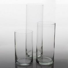 three tall glass vases sitting next to each other