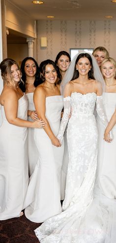 a group of bridesmaids pose for a photo in their wedding dress gowns