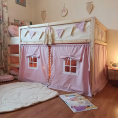 there is a pink tent bed with curtains on the top and bottom bunk above it