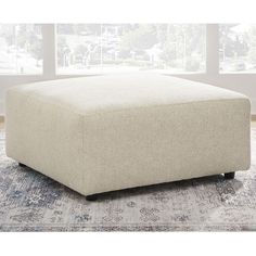 a large white ottoman sitting on top of a rug