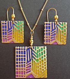 An Art-Deco pattern is embossed on solid brass and painted in rainbow colors; then the brass is sanded to reveal the metal beneath and polished to a shine. The earrings are attached to gold plated or solid brass hook wires, and the pendant comes with a chain or cord and lobster claw clasp. Round set: solid brass earring wires and black rattail pendant cord. Square set: gold plated earring wires and gold tone chain. Multicolor Hand Painted Metal Jewelry, Hand Painted Multicolor Metal Jewelry, Hand Painted Gold Metal Jewelry, Unique Multicolor Patina Jewelry, Unique Multicolor Jewelry With Patina, Etched Gold Copper Jewelry, Etched Copper Gold Jewelry, Artistic Multicolor Copper Jewelry, Unique Multicolor Brass Jewelry