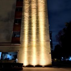 a tall clock tower lit up at night with lights on it's sides and windows