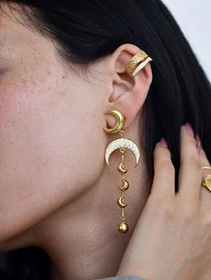 Add a touch of celestial charm to your style with these stunning Luna Earrings. Handcrafted with precision, these earrings feature a delicate crescent moon design, beautifully enameled to create a unique, elegant look. Made from high-quality brass and finished with a luxurious gold-filled coating, they offer durability along with timeless beauty. The lightweight dangle design ensures comfort, making them perfect for everyday wear or special occasions. Whether you're treating yourself or gifting Luxury Unique Enamel Earrings, Luxury Hand-tooled Jewelry For Festivals, Celestial Gold Plated Moon Earrings, Gold Moon-shaped Cartilage Earrings, Celestial Gold Plated Single Earring, Gold Single Moon-shaped Earring, Gold Moon Shaped Cartilage Earrings, Celestial Single Gold Plated Earring, Celestial Gold-plated Single Earring