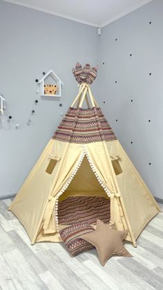 a teepee tent sitting on top of a wooden floor