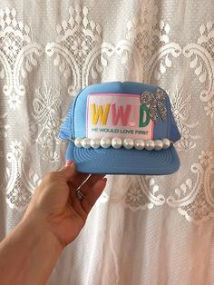 Inspire and uplift with this beautiful Blue "WWJD - He Would Love First" Trucker Hat! Featuring a colorful embroidered patch with the acronym "WWJD" (What Would Jesus Do) and the powerful message "He Would Love First," this hat is perfect for expressing your faith with a stylish twist. The addition of a sparkling glitter bow and a row of elegant pearls adds a unique and charming flair.  This hat along with all of my other trucker hats are handmade, one of a kind and made to order. Designed for b Trucker Hat Charms, Christian Trucker Hats, Trucker Hats With Patches Diy, Trucker Hat Patches, Patch Trucker Hat, Cute Trucker Hats, Trucker Hat Bar, Trucker Hats With Patches, Trucker Hat Designs