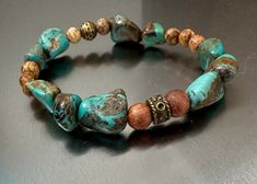 Kingman Mine Turquoise Nugget, this beautiful set of healing bracelets for Women and Men. Can also be purchased separately. Use this link to receive $20 off your order of $80 https://www.etsy.com/shop/EarthStoneByCaroline?coupon=20OFF80 Two stackable stretchy bracelets made to order One bracelet has smaller turquoise nuggets from the kingman mine in Arizona with crazy lace agate 6mm, a silver bead to cover the knot The other bracelet has larger kingman turquoise nuggets ranging between 10mm-12mm, with brown picture jasper 6mm and sandalwood 6mm, a center antique silver bead and silver knot cover. Kingman Turquoise The Kingman Turquoise Mine is one of the oldest and highest producing Turquoise Mines in America. It was originally discovered by prehistoric Indians well over 1000 years ago. Ki Bohemian Brown Stretch Bracelet For Meditation, Bohemian Stretch Bracelet With Natural Stones For Healing, Bohemian Natural Stones Stretch Bracelet For Healing, Earthy Turquoise Bracelets For Festival, Earthy Turquoise Beaded Bracelets For Healing, Rustic Turquoise Beaded Bracelets With Natural Stones, Bohemian Turquoise Stretch Bracelet Hand-strung, Handmade Turquoise Bohemian Stretch Bracelet, Bohemian Turquoise Stretch Bracelet For Meditation