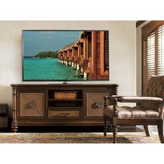 a large flat screen tv sitting on top of a wooden cabinet in a living room