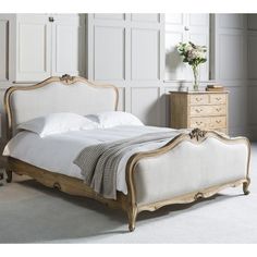 a white bed sitting in a bedroom next to a dresser