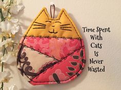 a close up of a cat on a wall with flowers in the background and text that reads time spent with cats is never wasted