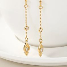 Touch Every Style with the Endless Sparkle Dangle Earrings! Where elegance and sparkle meet: Add a touch of dazzling elegance to your style anytime with the Endless Sparkle Dangle Earrings. These earrings, featuring 18K gold-plated chains dangling on long stainless steel chains and adorned with cubic zirconia stones, will accompany you every moment, from your daily life to special nights. Areas of Use: An ideal choice for women who love elegance in everyday life. Can be used to achieve an elegan Elegant Gold Long Drop Linear Earrings, Elegant Gold Long Drop Chandelier Earrings, Elegant Dangle Threader Earrings With Delicate Chain, Gold-tone Drop Earrings With Adjustable Chain, Elegant Linear Drop Earrings With Delicate Chain, Elegant Gold Dangle Linear Earrings, Elegant Gold-tone Crystal Drop Earrings, Gold Linear Earrings With Delicate Chain For Formal Events, Elegant Long Drop Chandelier Earrings With Dangling Charms