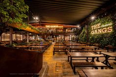 an outdoor restaurant with tables and benches at night