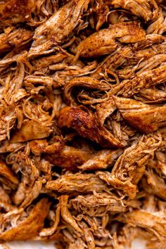 shredded meat sitting on top of a white plate