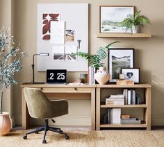 a desk with a chair and pictures on the wall above it, next to a potted plant