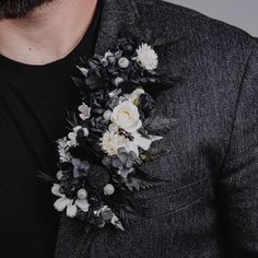 a man wearing a black and white flowered boutonniere on his lapel