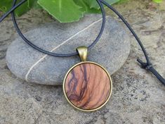 "Lovely bronze pendant medallion with a handmade cabochon Ø 25 mm - 0.98 inches in fine olive wood with a 75 cm - 29.5 inches long bronze plated chain or an adjustable leather cord 1 meter ( 39.37 \" ) naturally the grain of the olive wood can vary from item to item , but in any case you will get a pendant with an olive wood cabochon with beautiful grain handcrafted by us in Portugal the olive wood is finely sanded and oiled with olive oil" Brown Amulet Style Round Pendant Necklace, Brown Medallion Amulet Necklace, Handmade Bohemian Round Disc Jewelry, Brown Amulet Style Necklace With Round Pendant, Handmade Bohemian Disc Jewelry, Brown Amulet Necklace With Round Pendant, Bohemian Handmade Round Disc Jewelry, Bohemian Natural Wood Necklaces As Gift, Bohemian Natural Wood Necklace As Gift