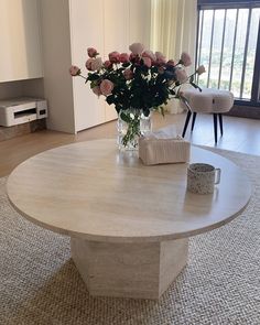 a vase with flowers sitting on top of a table in front of a sliding glass door