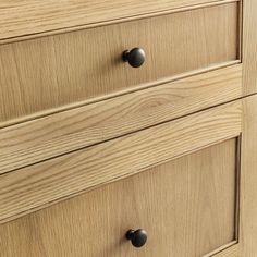 a wooden dresser with black handles and knobs