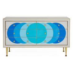 a blue and white dresser with gold accents