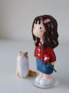 there is a small figurine with a cat next to it