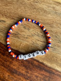 Whether you're attending a game at Comerica Park, gathering with fellow fans to cheer on the Tigers, or simply want to showcase your team pride on any occasion, this Detroit Tigers themed beaded bracelet is the perfect accessory. It adds a touch of team spirit and a fashionable statement to your ensemble. This bracelet also makes a thoughtful gift for friends, family, or any Detroit Tigers enthusiast in your life. It's a symbol of camaraderie and shared love for the team, making it a cherished m Team Spirit Bracelets With Letter Beads, Team Spirit Beaded Bracelets For Game Day, Team-colored Sports Bracelets With Letter Beads, Team-colored Bracelets With Letter Beads For Sports, Team-colored Letter Beads Bracelets For Sports, Game Day Team Spirit Stretch Bracelet With Round Beads, Game Day Bracelets With Letter And Round Beads, Adjustable Team-colored Beaded Bracelets, Team Spirit Round Beads Jewelry For Game Day