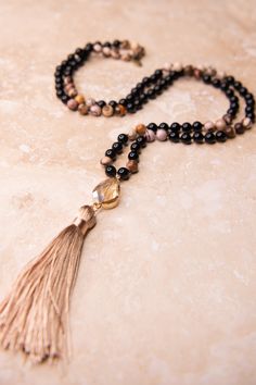 Elevate your look with our Tama Necklace Onyx. A stunning combination of long sandstone beads, a dazzling crystal pendant, and a luxurious tassel. Make a statement and add a touch of elegance to any outfit. Perfect for the fashion-forward and sophisticated! Long Necklace Boho, Beaded Tassel Necklace, Stone Beaded Necklace, Onyx Necklace, Stylish Necklace, Beaded Tassels, How To Make Beads, Crystal Pendant, Stone Necklace