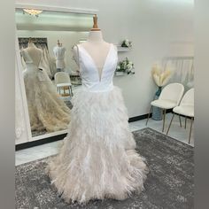 a mannequin is dressed up in a feathery white dress with a deep v - neckline