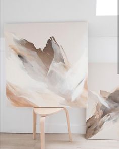 an abstract painting is displayed next to a chair