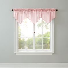 a window with pink ruffled valance hanging from it's side in front of a white wall