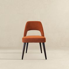 an orange chair sitting on top of a white floor