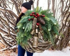 a woman carrying a wreath and bells in the snow