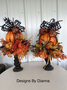 two pumpkins decorated with black and white bows sit on top of a round table