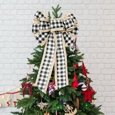 a decorated christmas tree in front of a brick wall