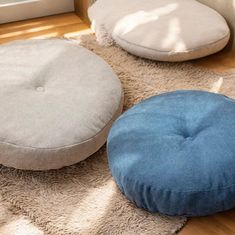 three round pillows sitting on top of a wooden floor