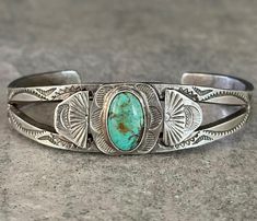 This is an exceptional Old Navajo sterling silver bracelet. This stunning Thick bracelet contains natural light green blue turquoise stone.Thick split shank bracelets embellished with hand carved & hand stamped silver panels on both sides of the center stone. Hand stamped across the bracelet. Circa 1920's-1930's There is no purity mark ,however it has been tested positive for sterling silver. The inside measurement from tip to tip is approximately 5-1/4" and the opening measurement between the tip is approximately 1-1/8" Approximate width of the bracelet is 2-3/8" (across inside). Sturdy 29.2 grams in my scale. STACKABLE Bracelet! This bracelet fits 6-1/4",6-1/2",6-3/4" size wrists. This bracelet would be a great addition to any Native American or Southwestern jewelry collection. This Beau Silver Bracelet Cuff, Southwestern Jewelry, Stackable Bracelets, Bracelet Cuff, Split Shank, Silver Cuff Bracelet, Old Vintage, Blue Turquoise, Turquoise Stone