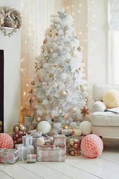 a white christmas tree with presents under it