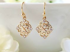 These lovely filigree earrings, have a beautiful 24k champagne gold finish. Tiny, clear zircon gemstones, embellish the ornate design. They are lightweight, making them comfortable to wear. Product details: - 18k gold plated ear wires; Lead and nickel free - 24k champagne gold filigree charm with clear zircon gemstones - Handmade, with lots of love and care! * Length:      .9 inches * Width:       .5 inches ❤ You can click here to see more unique jewelry from Flutterbird: https://www.etsy.com/shop/FlutterbirdCo My goal is to provide every customer with exceptional service. Please message me if you have any questions. Thank you for supporting my small business!  Please visit my F.A.Q. and shop policy sections for additional info. Gold Minimalist Earrings, Zircon Gemstone, Minimalist Earrings Gold, Ornate Design, Filigree Earrings, Handmade Jewelry Gift, Earrings Dainty, Gold Filigree, Dainty Earrings