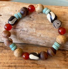 This bracelet is a colorful mix of ethnic beads, bright carnelian stones, desert jasper, Tibetan agates and  matte green glass rondelles handcrafted in Java, Indonesia.  It's an African inspired bracelet with a southwestern feel.  I try to combine stones of different finishes  because it brings out the best of all.  Beads are 10mm-12mm.  7" long which fits most wrists but I can customize the length  for no additional cost.  Strung on top quality stretch cord for ease and comfort.  All my pieces arrive in a rustic burlap gift bag ready to give or to keep for yourself.  Hkpdesigns.etsy.com Clothespin Diy Crafts, Clothespins Diy, Desert Jasper, Burlap Gift Bags, Multi Gemstone Bracelet, Carnelian Bracelet, Matte Green, Carnelian Stone, Glass Bracelet