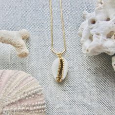 We love this fun and summery, beachy necklace. Answer the siren's song and get one for yourself or someone you love. Would make a great gift for the surfer or beach-lover in your life! A 14k gold electroplated cowrie shell dangles from a lustrous, high quality gold filled snake chain. The perfect summertime accessory! Chain length 16"✦ JEWELRY CARE ✦✧ Warm water and a soft cloth are the best thing you can do to maintain the beauty of your jewelry.✧ Jewelry polishing cloths work great and are non Gold Shell Necklace With Starfish Charm For Summer, Beachy Gold Shell Necklace As A Gift, Beachy Gold Shell Necklace For Gifts, Beachy Gold Shell Necklace For Gift, Beachy Gold Shell Necklace Perfect For Gifts, Gold Shell Necklace With Starfish Charm For Vacation, Dainty Gold Jewelry For Vacation, Gold Strand Jewelry For Gift, Beachy Gold Jewelry With Starfish Charm