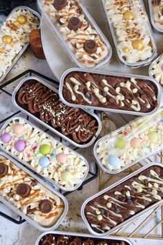 an assortment of desserts in plastic containers on a table