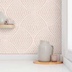 a white vase sitting on top of a counter next to a wallpapered wall