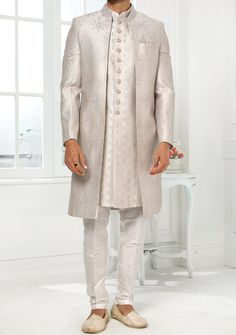 Readymade Art Silk Sherwani, and Jacket. Art Dupion Aligarhi Ready Made Trouser. Resham, Sequences, and Zari Work. Crafted in Chinese Collar Neck, and Full Sleeve. Faux Satin Lining with Plain Work. High-Quality Matching Buttons. Please Note: The footwear shown in the picture is for presentation and photography purpose only. Color: There might be slight color variation due to lightings and flashes while photo shooting. The color may also vary because of different screen resolutions. Wash Care: D Cream Sherwani, Western Party Wear, Suit With Jacket, Indo Western Sherwani, Jacket Art, Western Party, Western Parties, Chinese Collar, Readymade Saree