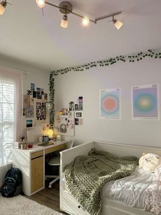 a bedroom with a bed, desk and pictures on the wall