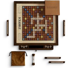 the scrabble board game is on display with other items including pens and pencils