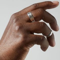 a person's hand with two rings on their fingers and one ring in the middle