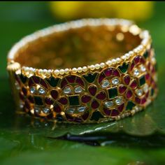 Description A vintage heirloom, our Indu silver bangle is inspired from timeless Indian jewelry featuring floral motifs. This bangle is infused with hundreds of kempu crystals that add a brilliant colors to the design. This bangle is part of Shruti Haasan edit, designed by Creative Director at Paksha. A great look for both weddings and special occasions. Product Information Materials used: 925 Silver with 1.0-microns Gold Plating Stones: Semi precious stones Length: 2.8 -6.5 cm Contains: Comes i Fusion Style Meenakari Bangle For Ceremonial Occasions, Multicolor Wedding Bangle With 17 Jewels, Celebration Bangle With Intricate Design, Ceremonial Kundan Fusion Bangle, Ceremonial Fusion Kundan Bangle, Festive Fusion Style Bangle With Hand Set, Festive Fusion Bangle With Hand Set, Fusion Style Meenakari Bangle For Celebrations, Jeweled Festival Bangle