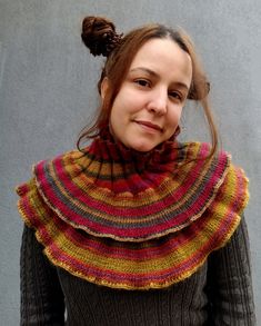 a woman wearing a knitted shawl and smiling at the camera