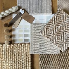 several different colors of woven material on a wooden table with white and gray paint swatches