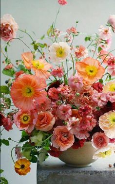 a vase filled with lots of different colored flowers