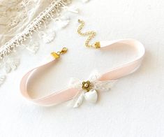 This romantic choker necklace is handmade with a soft blush pink double sided velvet ribbon. It features a vintage lace ribbon bow, pearl beaded jewel, and a beautiful vintage mother of pearl heart charm. A lovely gift for women who love to wear unique jewelry.  See last photos showing coordinating necklaces! This necklace is also available in blue, white and black velvet... sold separately in the Rosy Posy Designs shop. * Size ~ Adjustable length 12 - 15 inches with extender chain  Please check Feminine Adjustable Ribbon Jewelry, Ribbon Choker Necklace For Weddings, Cute Bow Jewelry For Wedding, Elegant Wedding Choker For Valentine's Day, Adjustable Wedding Choker For Valentine's Day, Feminine Adjustable Choker For Wedding, Pink Ribbon Wedding Jewelry, Girlfriend Necklace Gift, Bow Choker