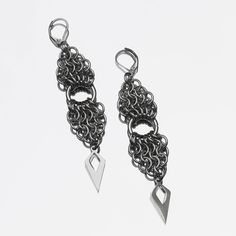 Ces boucles d'oreilles ont deux parties dans un pattern "European" en forme de triangle, liées par un grand anneau central. Ce design est renforcé par les perles de forme géométrique qui rappellent la forme globale. Gunmetal Dangle Jewelry, Gunmetal Dangle Earrings Metal Jewelry, Gunmetal Dangle Earrings, Modern Teardrop Stainless Steel Earrings, Elegant Triangle Metal Earrings, Elegant Triangle Metal Jewelry, Handmade Gunmetal Metal Jewelry, Modern Handmade Stainless Steel Earrings, Triangle Metal Earrings For Gift